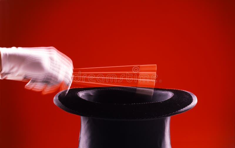 Magic. White gloved hand waving over to had on red background Magic. White gloved hand waving over to had on red background
