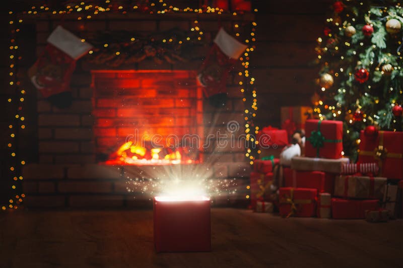 Magic Christmas present at the Christmas tree and fireplace stock photo