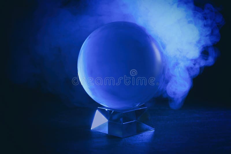 Magic Crystal Ball on Table and Smoke Against Dark Background. Making