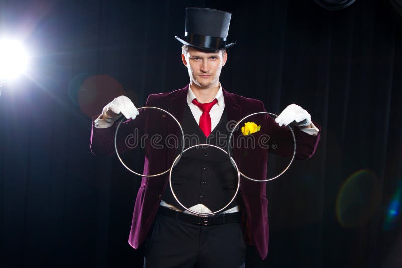 Magic, performance, circus, show concept - magician in top hat showing trick with linking rings royalty free stock photo Magic, performance, circus, show concept - magician in top hat showing trick with linking rings royalty free stock photo