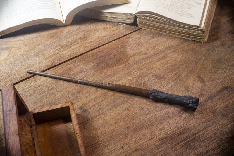 Magic wand on a wooden table with an open book