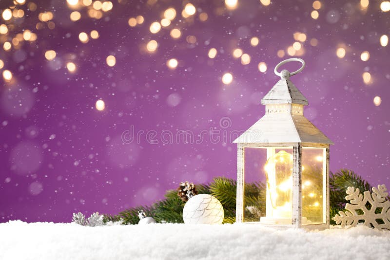 Magical Lantern with christmas toys on a snow against purple background