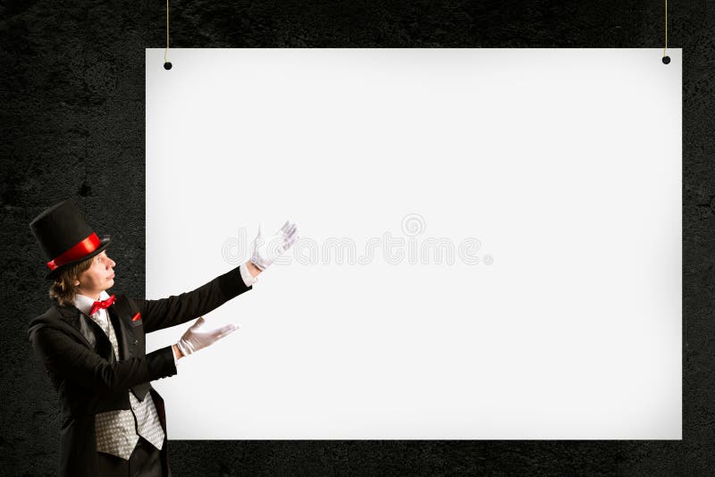 Magician in top hat and tie points to the banner royalty free stock photography