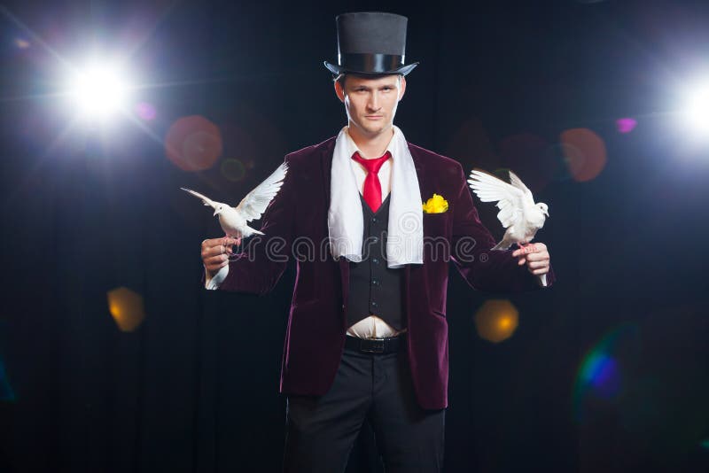 The magician with a two flying white Doves. on a black background royalty free stock image The magician with a two flying white Doves. on a black background royalty free stock image
