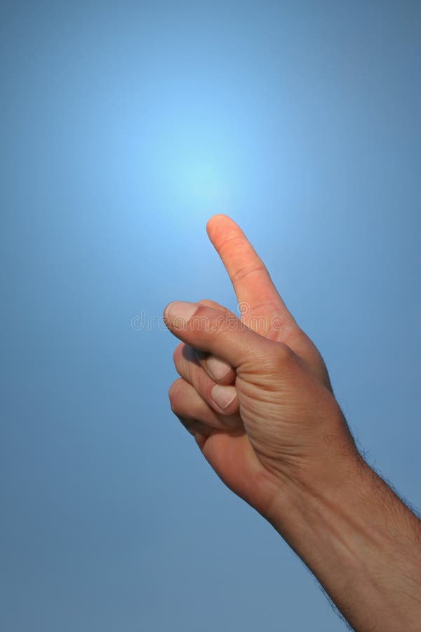 Hand of a man pointing his forefinger to towards a blue sky with a light glow coming from his forefinger. Focus on the forefinger. Hand of a man pointing his forefinger to towards a blue sky with a light glow coming from his forefinger. Focus on the forefinger.