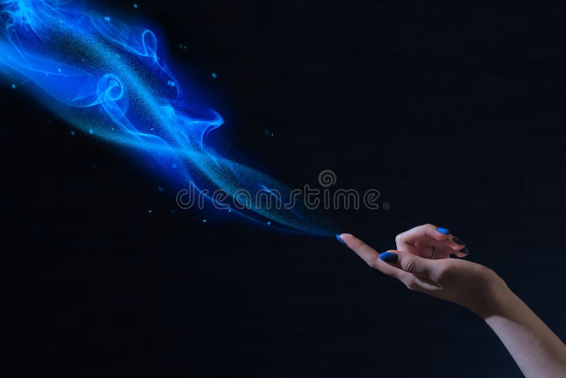 Magic hand, conceptual image with glow on a black background, blue magic, magical dust, the power of the sorceress, female charms. Magic hand, conceptual image with glow on a black background, blue magic, magical dust, the power of the sorceress, female charms