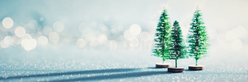Magică miniatură a minunilor bannere. pomi de Crăciun verzui pe fond albastru strălucitor. stock image