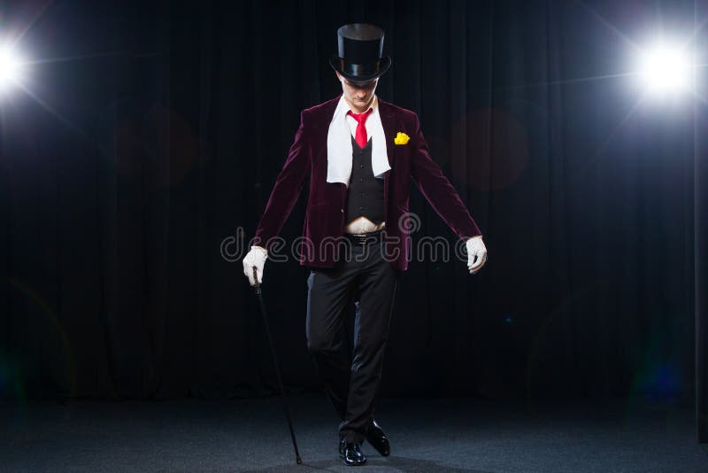 Magier, Jongleurmann, lustige Person, schwarze Magie, Illusion, die auf dem Stadium mit einem Stock des schönen Lichtes steht lizenzfreies stockbild Magier, Jongleurmann, lustige Person, schwarze Magie, Illusion, die auf dem Stadium mit einem Stock des schönen Lichtes steht lizenzfreies stockbild