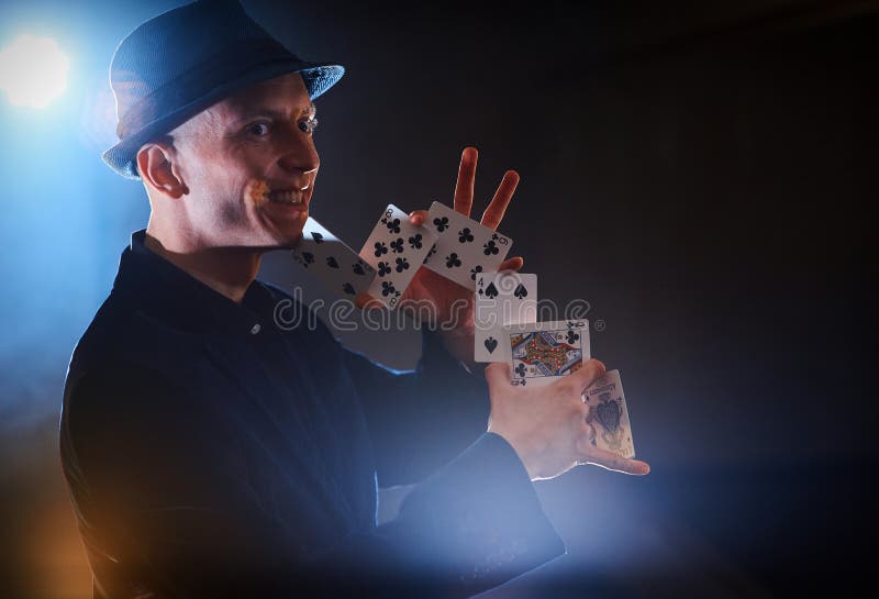 Magika seansu sztuczka z karta do gry Magia lub zręczność, cyrk, uprawia hazard Kuglarka w ciemnym pokoju z mgłą obraz stock Magika seansu sztuczka z karta do gry Magia lub zręczność, cyrk, uprawia hazard Kuglarka w ciemnym pokoju z mgłą obraz stock