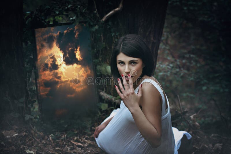 Magische spiegel en verraste vrouw in donker bos royalty-vrije stock foto Magische spiegel en verraste vrouw in donker bos royalty-vrije stock foto