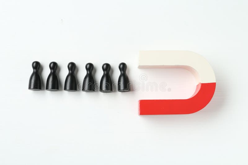 Magnet attracting black game pieces on white background, flat lay royalty free stock photos