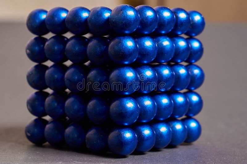 Cube Made of Blue Metal Balls on a Colored Background Stock
