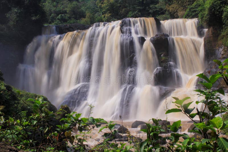 A magnificent, wide waterfall cascading over a series of dark rocks. royalty free stock photos