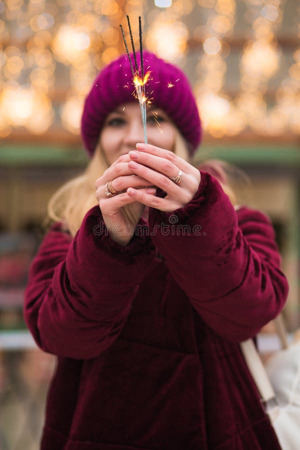 Magnificent blonde girl holding glowing Bengal lights at the Christmas fair in Kiev. Blur effect royalty free stock photos Magnificent blonde girl holding glowing Bengal lights at the Christmas fair in Kiev. Blur effect royalty free stock photos