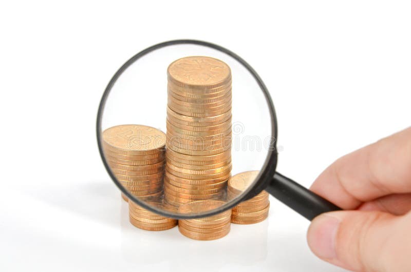 Magnifier glass and coins royalty free stock photo