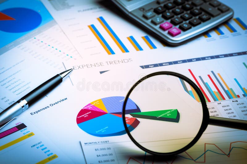 Magnifying Glass and Calculator on Business Graphs