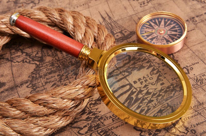 Magnifying glass and compass on the ancient map