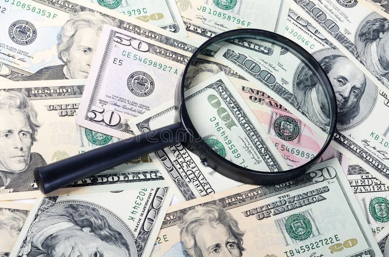 The magnifying glass lying on banknotes closeup