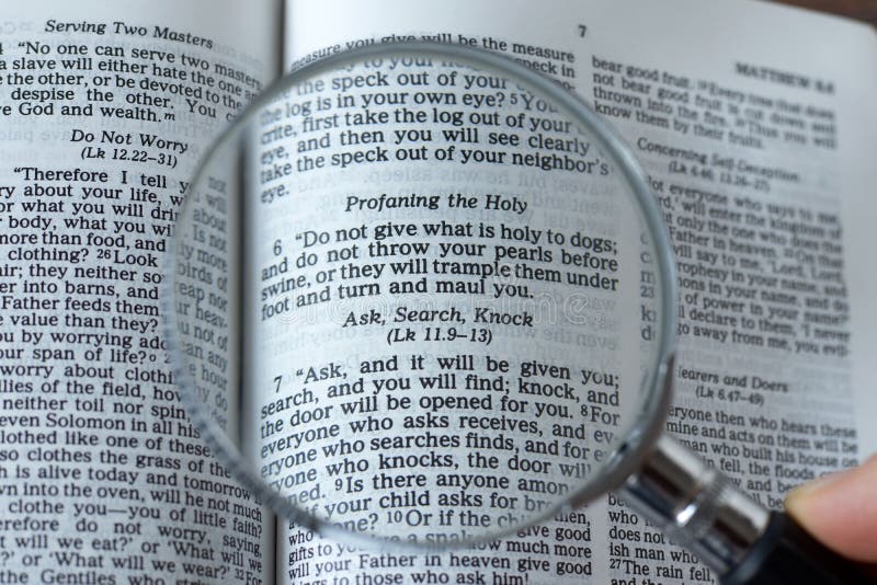 Magnifying glass over open Holy Bible Book, close-up, ask, search, knock verse, Matthew 7:7 Scripture text