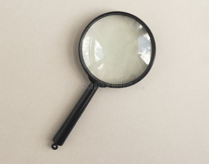 Magnifying glass over pale beige background. Magnifier as concept of finding answers royalty free stock image
