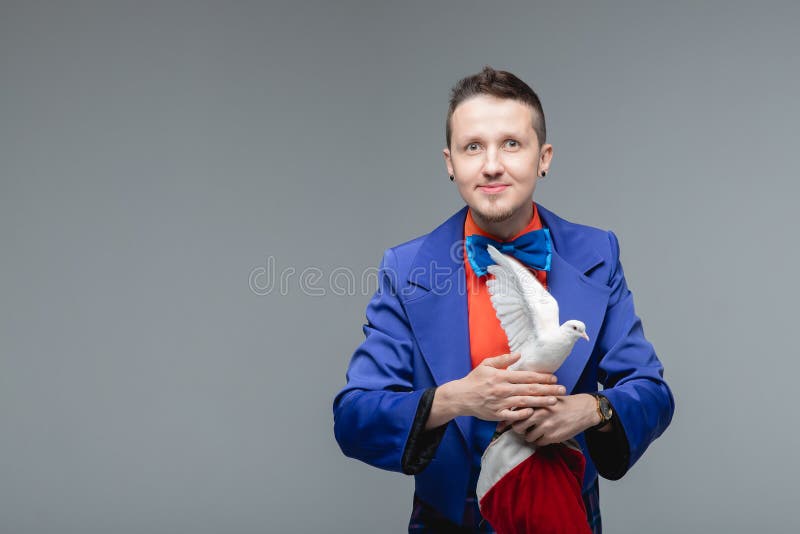Mago mostra un trucco con un uccello di colomba bianco addestrato fotografie stock