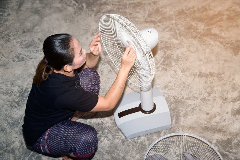 The Maid is Assembling and Installing an Electric Fan after Cleaning