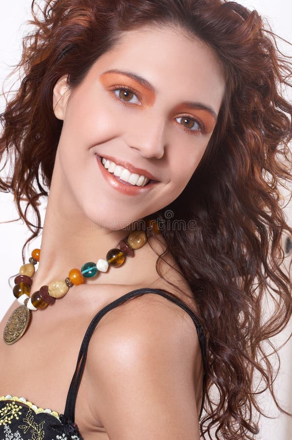 The beautiful girl with curly hair from a necklace from natural stones on a neck. She smiles. Lovely european female stock images, royalty-free photos and pictures