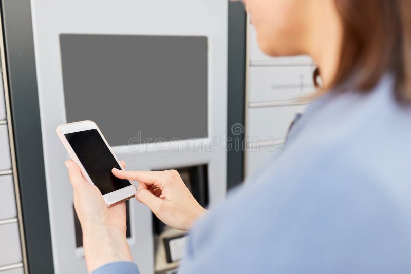 Woman with smartphone at automated parcel machine stock photos