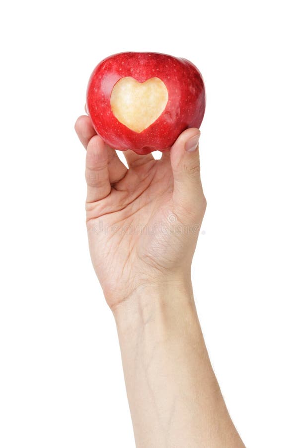 Main adulte d'homme tenant la pomme avec le coeur découpé images libres de droits Main adulte d'homme tenant la pomme avec le coeur découpé images libres de droits