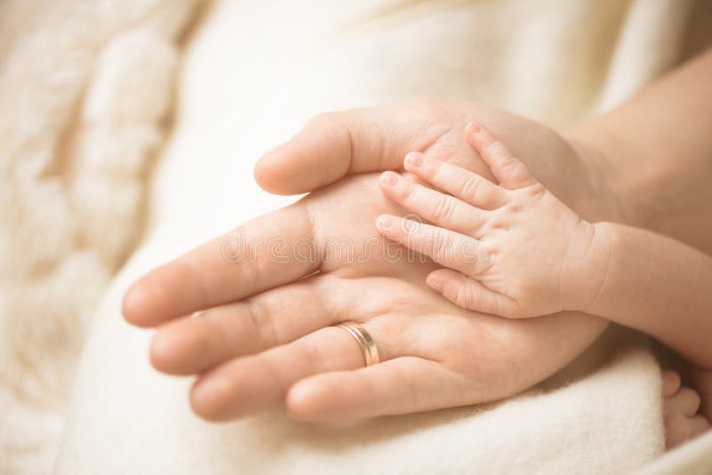 Main d'enfant nouveau-né Plan rapproché de main de chéri dans des mains de parents Concept de famille, de maternité et de naissan photo stock Main d'enfant nouveau-né Plan rapproché de main de chéri dans des mains de parents Concept de famille, de maternité et de naissan photo stock