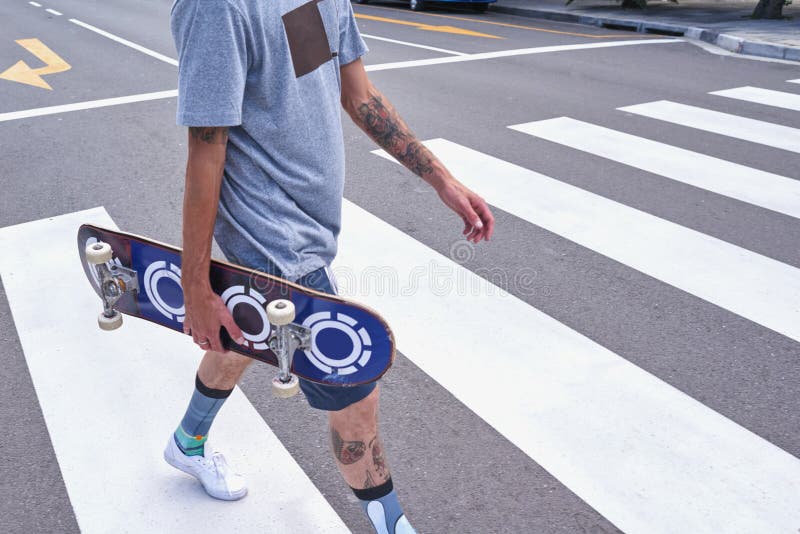 Main d'homme et marche avec skateboard en ville sur la traversée piétonne pour les déplacements ou le voyage. Homme image stock