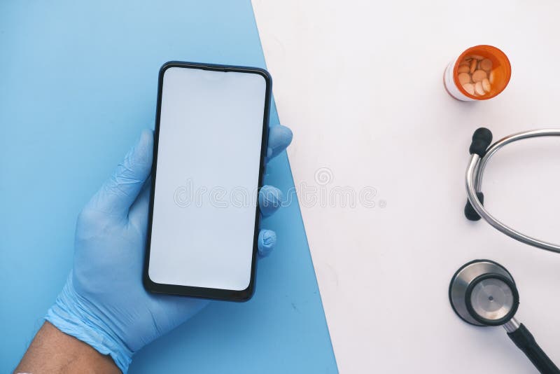 Main dans des gants en latex tenant téléphone intelligent avec écran vert.