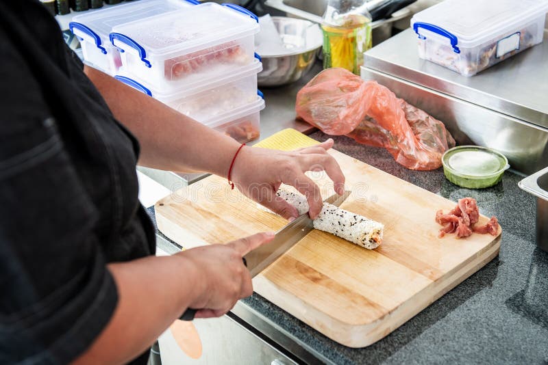 Main de chef faisant le petit pain de sushi japonais Le chef japonais au travail prépare le petit pain de sushi délicieux avec le photographie stock libre de droits Main de chef faisant le petit pain de sushi japonais Le chef japonais au travail prépare le petit pain de sushi délicieux avec le photographie stock libre de droits