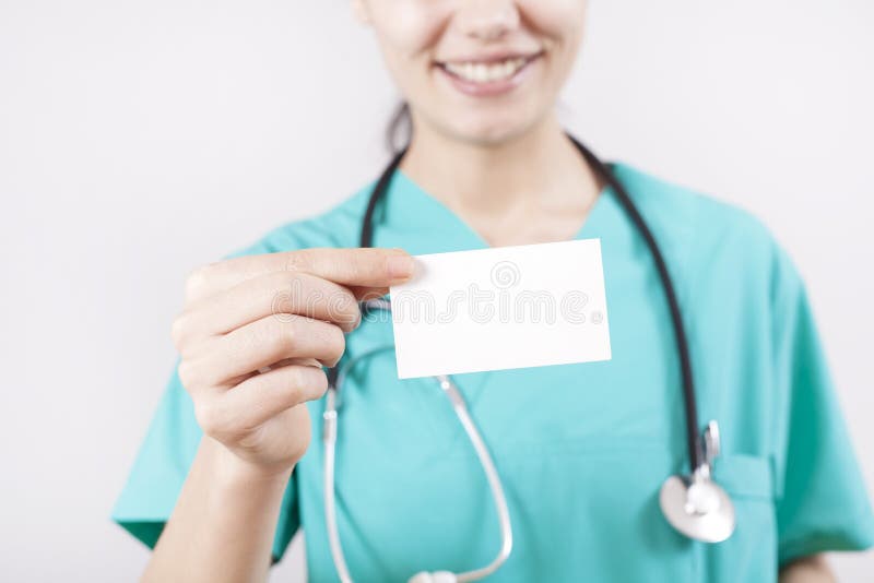 Main de docteur de jeune femme tenant la carte vierge sur le fond gris photo libre de droits Main de docteur de jeune femme tenant la carte vierge sur le fond gris photo libre de droits