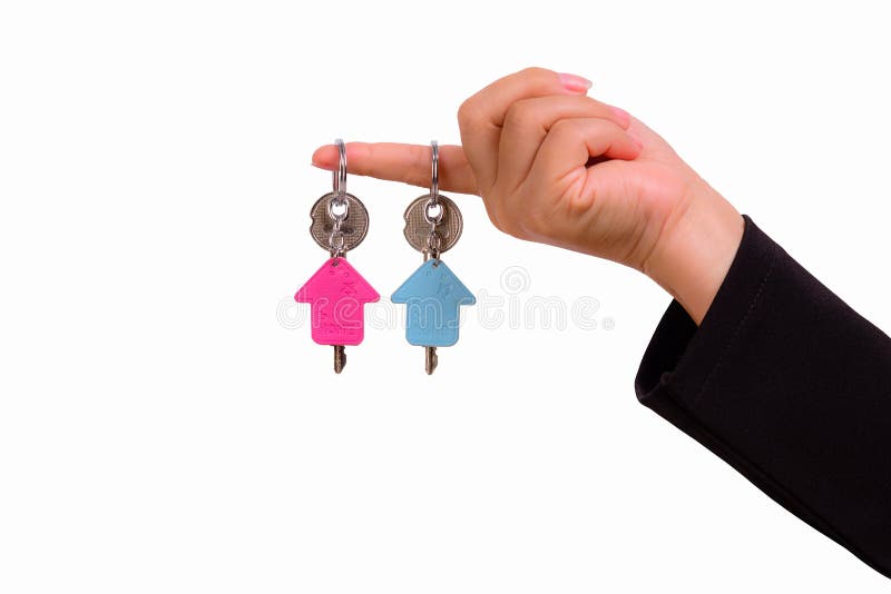 Main de femme avec le keychain deux sous forme de maison photo libre de droits Main de femme avec le keychain deux sous forme de maison photo libre de droits