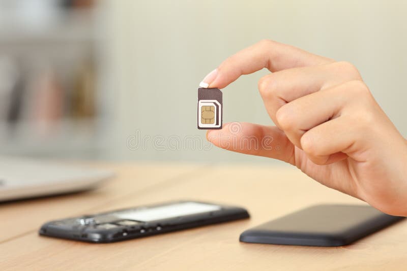 Close up of a woman hand holding sim card different sizes at home. Close up of a woman hand holding sim card different sizes at home