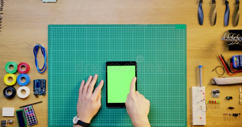 Main de personne et technicien avec tablette écran vert ci-dessus dans tutoriel publicitaire ou classe en ligne. vue supérieure clips vidéos