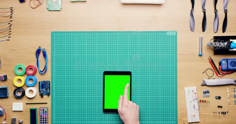 Main de technicien et tablette écran vert ci-dessus dans le tutoriel publicitaire ou classe en ligne. vue supérieure de l'ingénieu clips vidéos