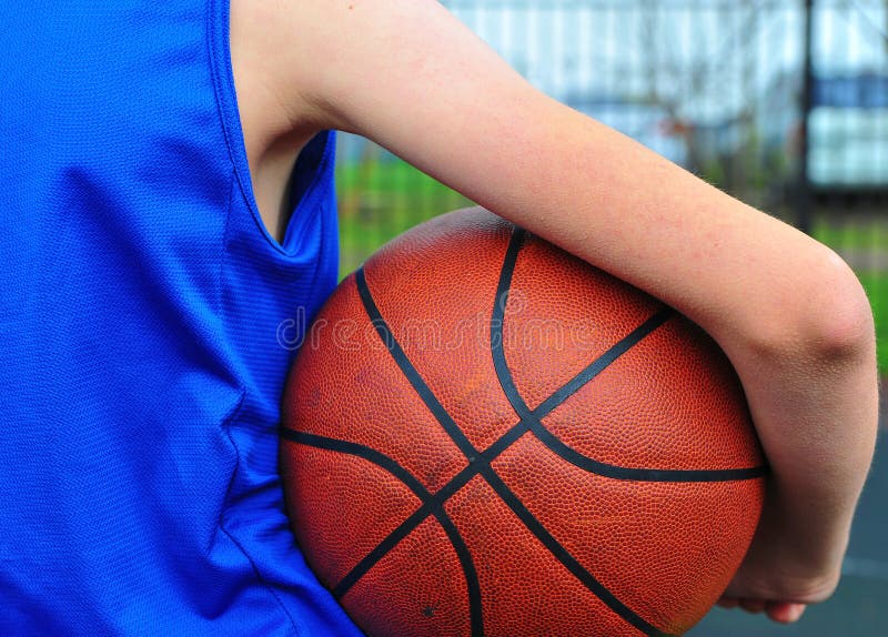 Main du ` s d'enfant tenant la boule de basket-ball photographie stock libre de droits Main du ` s d'enfant tenant la boule de basket-ball photographie stock libre de droits
