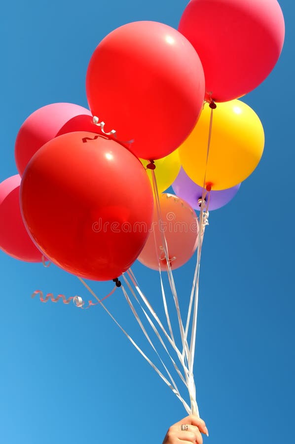 Main du ` s de femme tenant le groupe de ballons multicolores image stock Main du ` s de femme tenant le groupe de ballons multicolores image stock