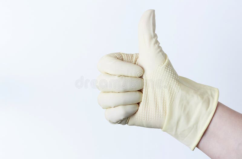 Main femelle dans les gants en caoutchouc avec augmenté son pouce sur un fond blanc photos libres de droits Main femelle dans les gants en caoutchouc avec augmenté son pouce sur un fond blanc photos libres de droits