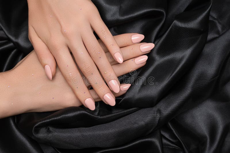 Main féminine avec la conception de l'ongle rose Manucure de vernis à ongles scintillante de Rose Main de femme sur le fond noir