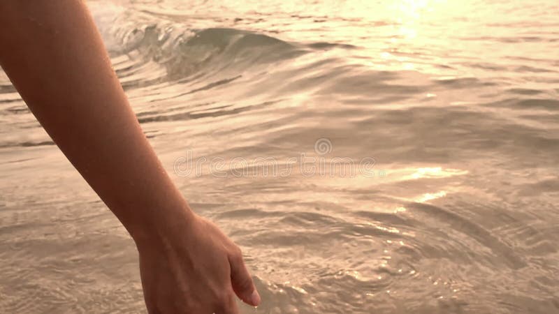 Main haute étroite de femme touchant des vagues d'eau de mer clips vidéos