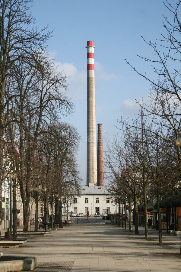 Main street of breclav, with its iconic giant chimney from the industrial area of the city. Breclav is a Czech city of Moravia