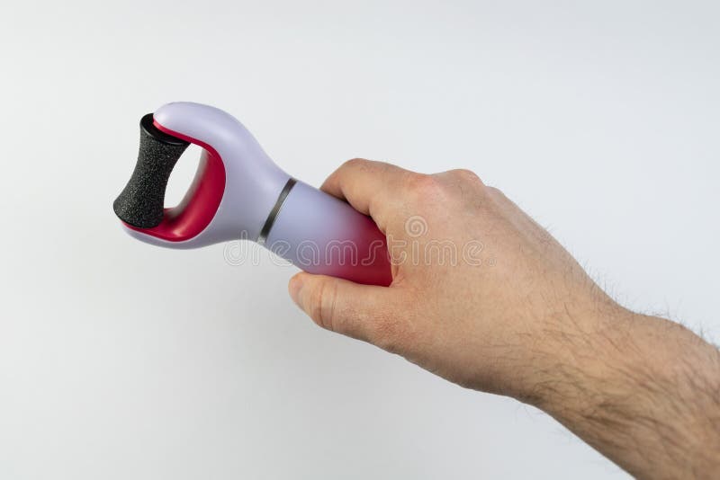 The main subject is out of focus, electric callus remover machine white background closeup remove old skin care treatment, male man hand hold