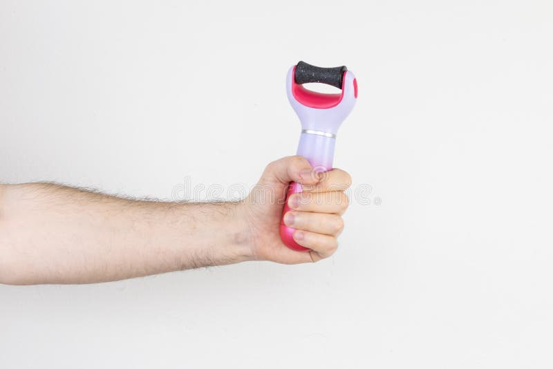 The main subject is out of focus, electric callus remover machine white background closeup remove old skin care treatment, male man hand hold