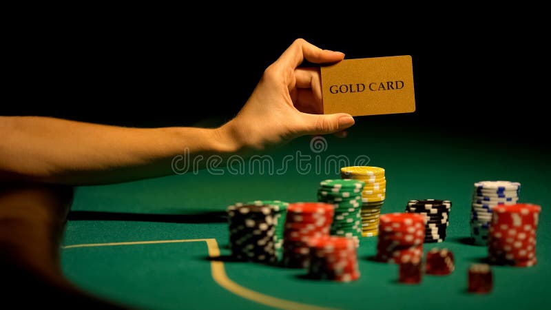 Main tenant la carte d'or, puces de jeu sur la table, casino ill?gal pour des VIP-clients image stock Main tenant la carte d'or, puces de jeu sur la table, casino ill?gal pour des VIP-clients image stock