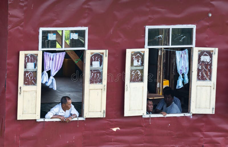 Maing Thauk, Myanmar - aprile 2019: uomo birmano anziano che guarda dalla finestra di galleggiamento della casa immagini stock libere da diritti Maing Thauk, Myanmar - aprile 2019: uomo birmano anziano che guarda dalla finestra di galleggiamento della casa immagini stock libere da diritti