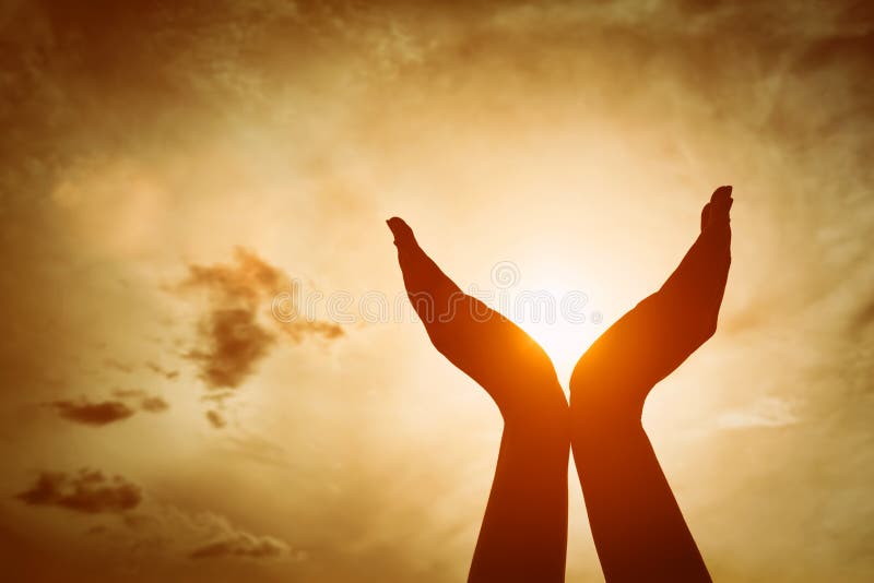 Mains augmentées attrapant le soleil sur le ciel de coucher du soleil Concept de spiritualité, bien-être, énergie positive
