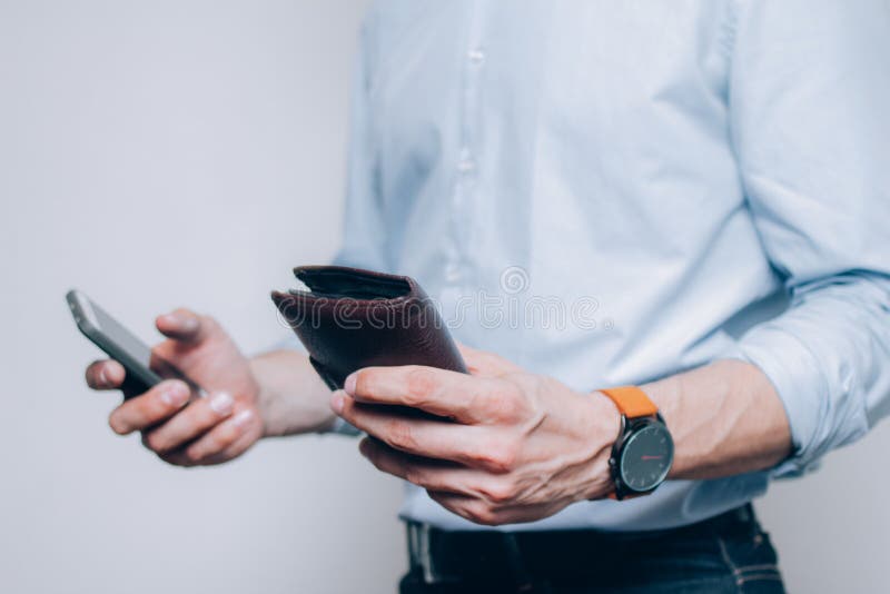 Mains avec le portefeuille et le smartphone bruns images stock Mains avec le portefeuille et le smartphone bruns images stock